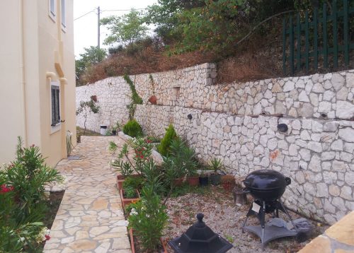 πέτρινος εξωτερικός χώρος με ελεύθερη χρήση μπάρμπεκιου